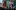 2022Hamlettour-groupshot A production image from 'Hamlet' directed by Tinuke Craig featuring seven people posing in formation dressed in red, green and purple outfits
