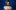 A blurred or shaken photo of a woman (Meera Syal), smiling and wearing gold jewellry and a blue dress.