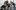 Drama-Teacher-Conference-2000x1250-Emma-Hare A group of six people are gathered around one person seated on a chair. They hold various props with dramatic facial expressions. The person in the middle holds her hands clasped together.