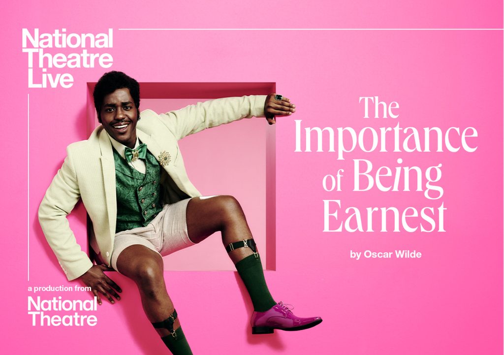 NTLive_TIoBE_CinemaListings_FA_1240x874px (1) A man wearing a smart jacket and shorts sits on a pink window.
