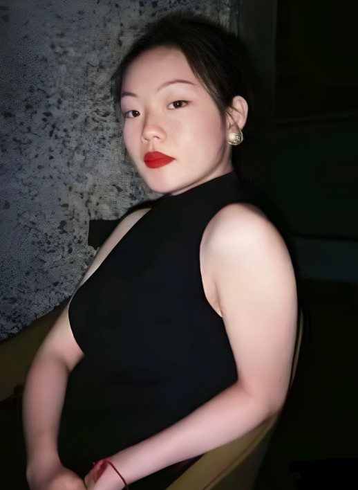 Peiyao-Wang-headshot-JoeLee-518x708 A photograph of a person wearing a sleeveless black top with black hair and red lipstick